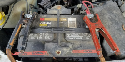 A car battery with jumper cables attached.